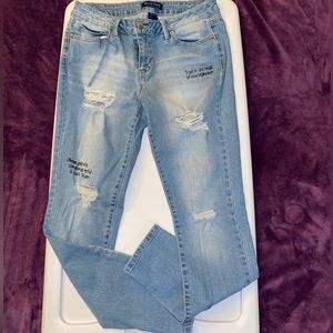 BLUEspice ripped jeans with writing on the front and back pocket